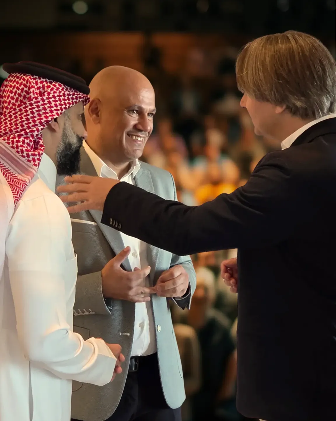 Imre van Gastel in conversation with two leaders at an event