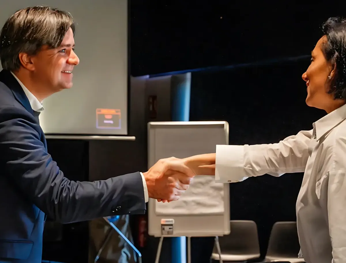 Imre van Gastel shaking hands with a participant at a workshop